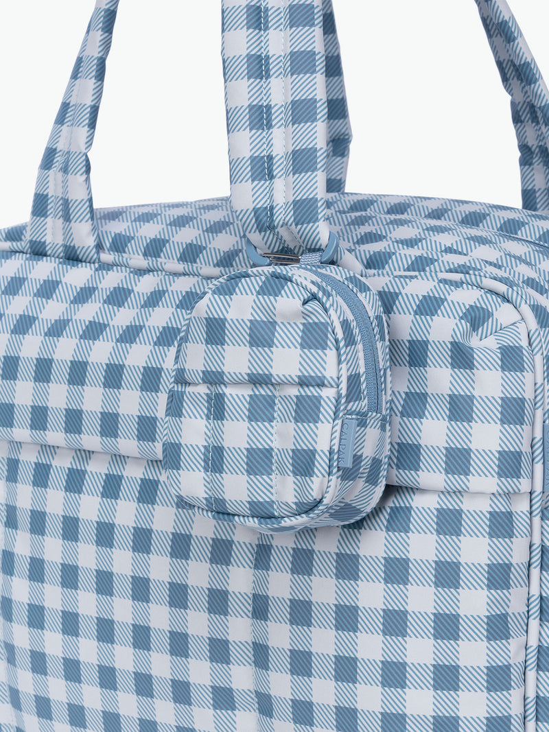 CALPAK Luka Backpack Zip Bag Charm in white and blue gingham print clipped on a bag