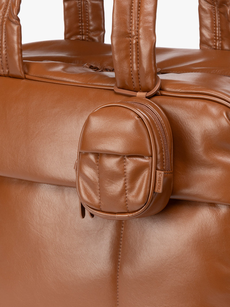 A close-up of light Honey Brown CALPAK Luka Backpack Zip Bag Charm leather backpack keychain featuring a matching bag shown on a plain white background