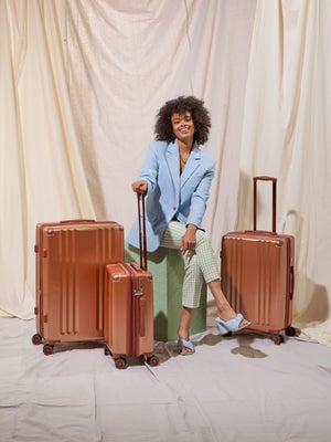 Model with all 3 pieces of the Ambeur luggage set in copper; LAM3000-COPPER