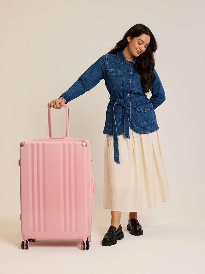 Model with CALPAK Ambeur Large Luggage in light pink Blossom