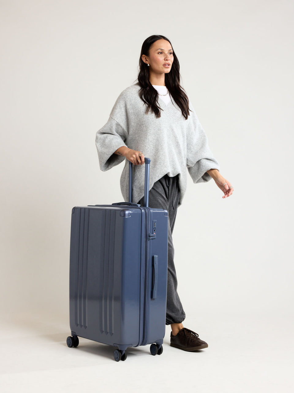 Person with CALPAK Ambeur Large Luggage in dark blue metallic Indigo; LAM1028-INDIGO