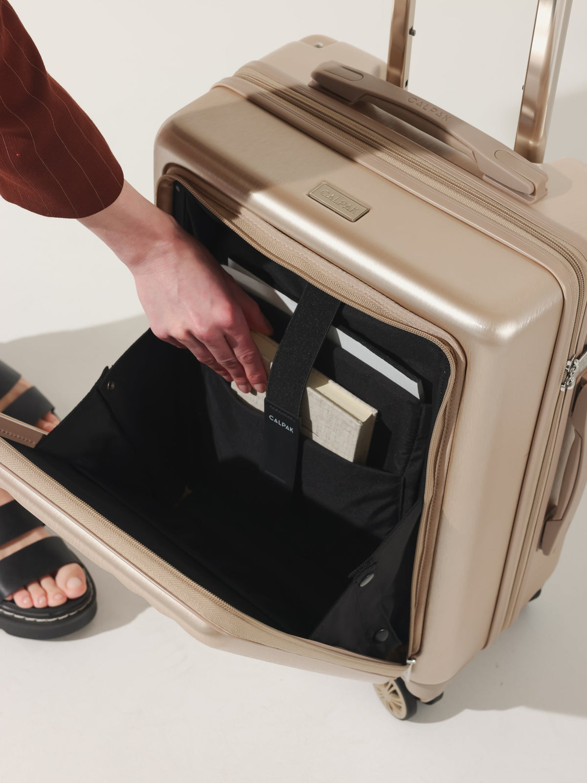 Model with CALPAK Ambeur carry on luggage with front pocket for laptop in gold; LAM1020-FP-GOLD