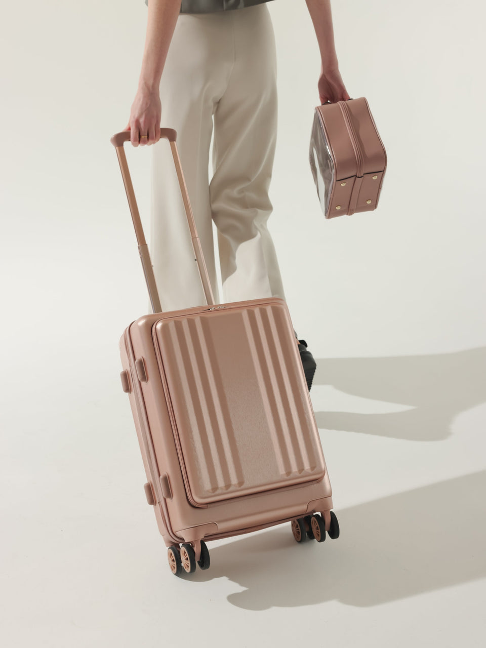 Model rolling CALPAK Ambeur carry on luggage with front pocket for laptop in rose gold; LAM1020-FP-ROSE-GOLD