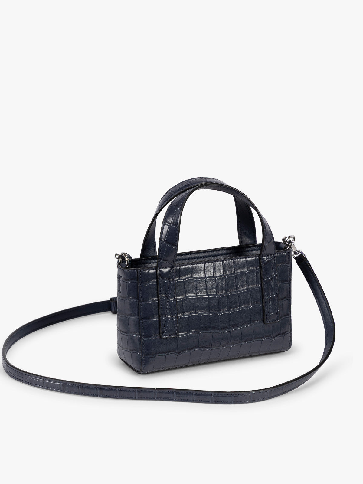 Side view with crossbody strap of A CALPAK Haven Mini Crossbody Bag in Navy blue crocodile-embossed with top handles on a plain white background; AMC2502-NAVY-FAUX-CROC