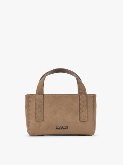 A CALPAK Haven Mini Crossbody Bag in brown Truffle Suede with top handles on a plain white background; AMC2502-TRUFFLE-FAUX-SUEDE view 1