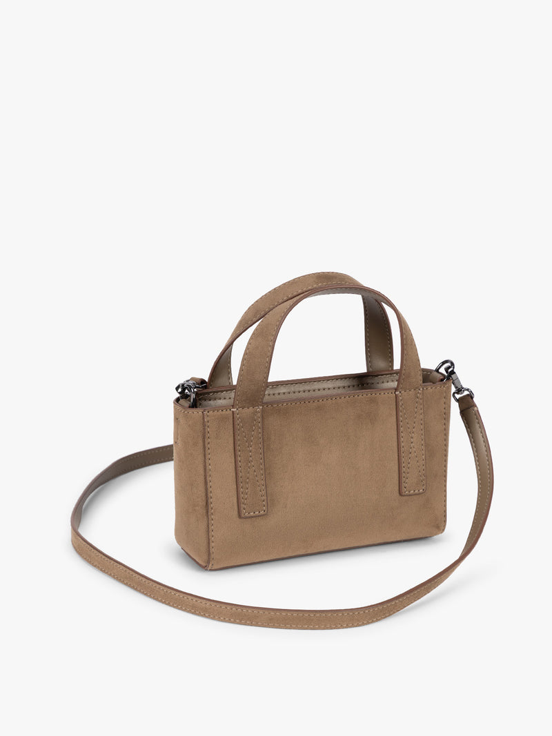 Side view with crossbody strap of CALPAK Haven Mini Crossbody Bag in brown Truffle Suede with top handles on a plain white background