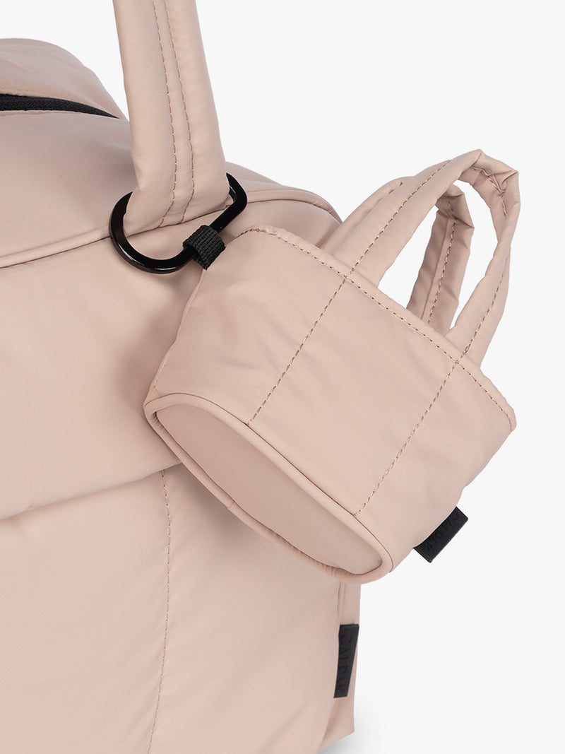 CALPAK Luka Tote Zip Bag Charm in light pink Rose Quartz  with carabiner attached to a bag