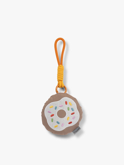 CALPAK Kids Pluffy Bag Charm white Donut with sprinkles on tan plush front view; APLF2501-DONUT view 1
