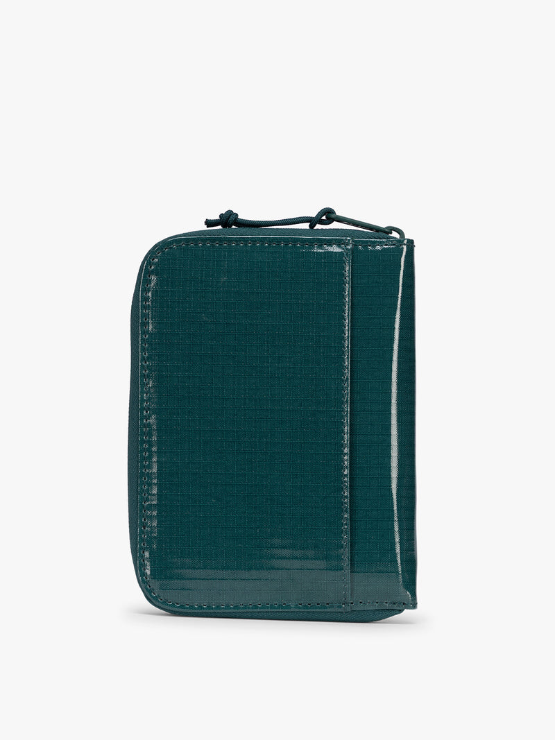 Back view of  CALPAK Terra Zip Passport Wallet in blue green Kale on a white background
