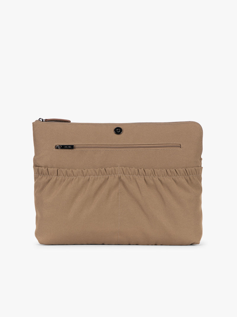 Laptop sleeve of CALPAK Haven 15" Laptop Tote in Truffle Suede taupe with dual top handles and a matching shoulder strap against a plain white background