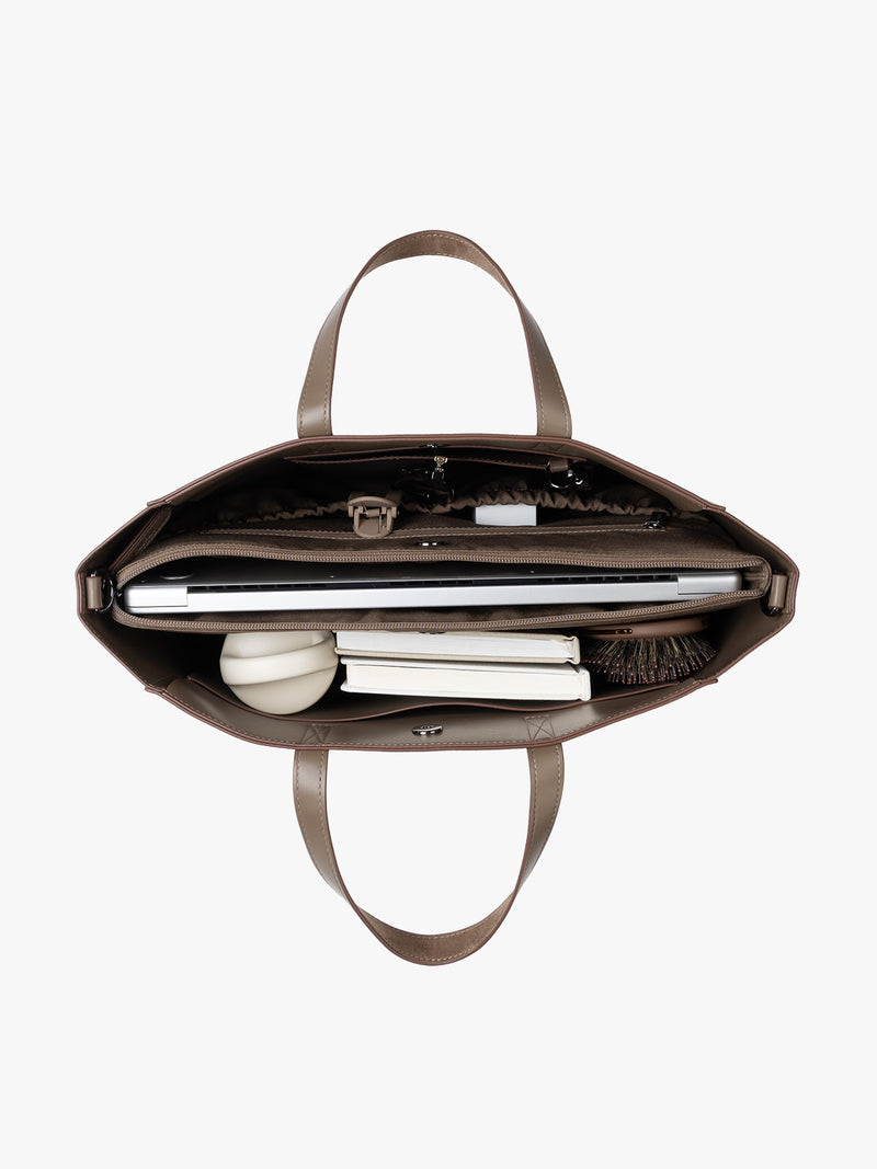 CALPAK Haven 15" Laptop Tote in Truffle Suede taupe with dual top handles and a matching shoulder strap with items inside against a plain white background