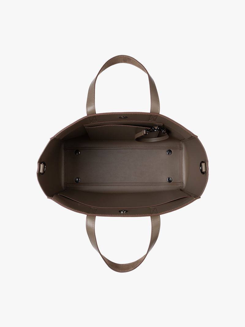 Top down view of CALPAK Haven 15" Laptop Tote in Truffle Suede taupe with dual top handles and a matching shoulder strap against a plain white background