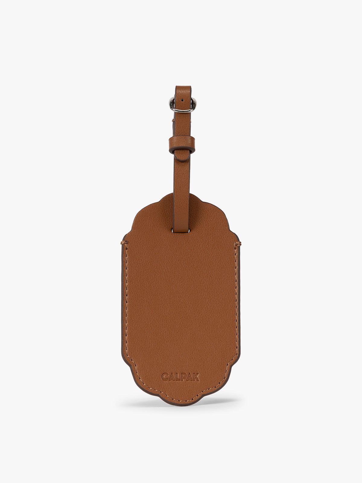 Backside of a honey brown CALPAK Vault luggage tag with a scalloped border and a matching honey brown strap, shown against a plain white background; ATV2601-HONEY-BROWN