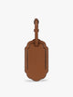 A honey brown CALPAK Vault luggage tag with a scalloped border and a matching honey brown strap, shown against a plain white background; ATV2601-HONEY-BROWN
