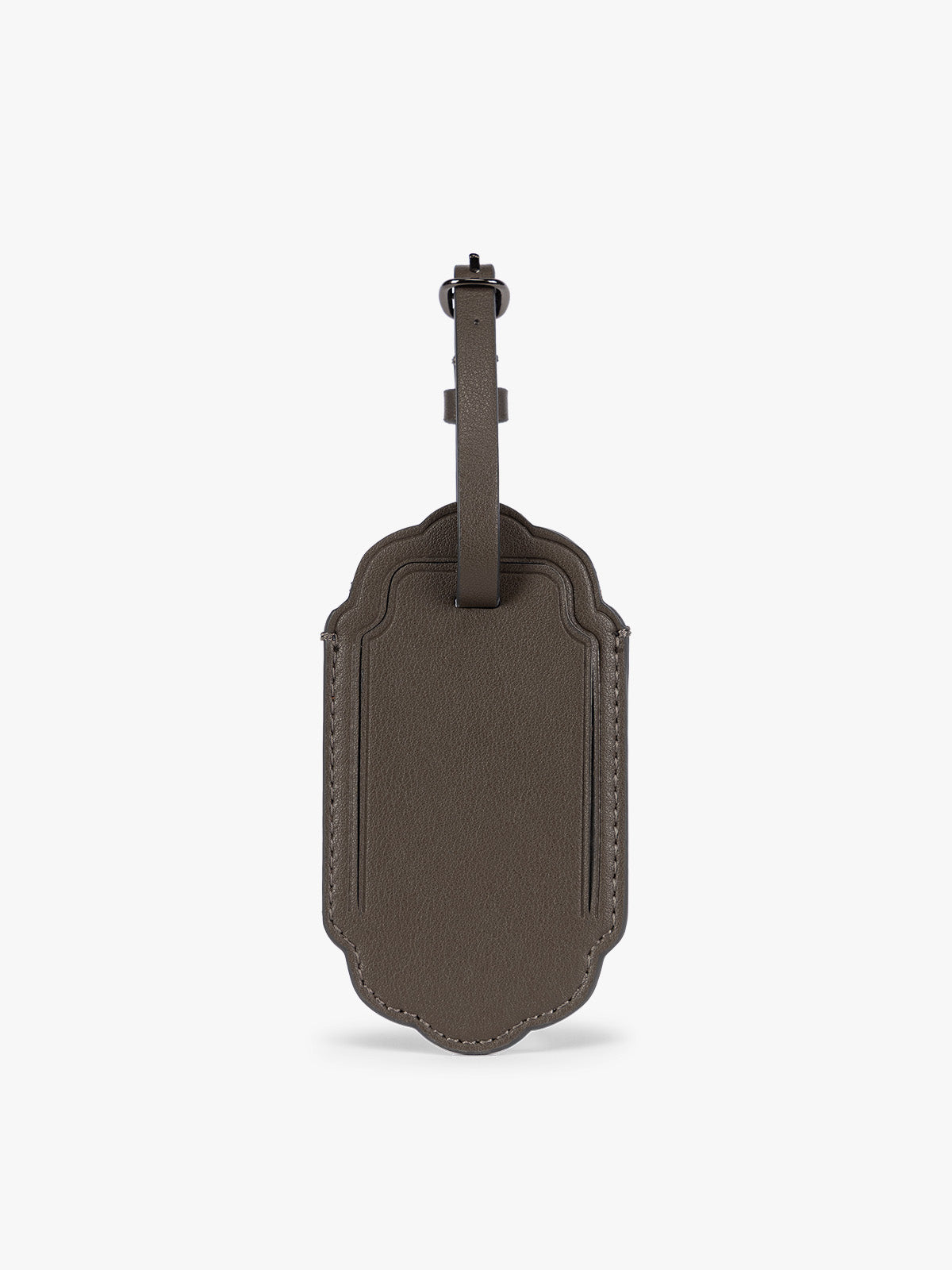 A dark brown CALPAK Vault luggage tag with a scalloped border and a matching dark brown strap, shown against a plain white background; ATV2601-MUSHROOM