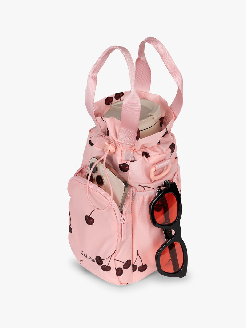 Water bottle in CALPAK Water Bottle Holder in Oatmeal Chery in pink with cherry pattern