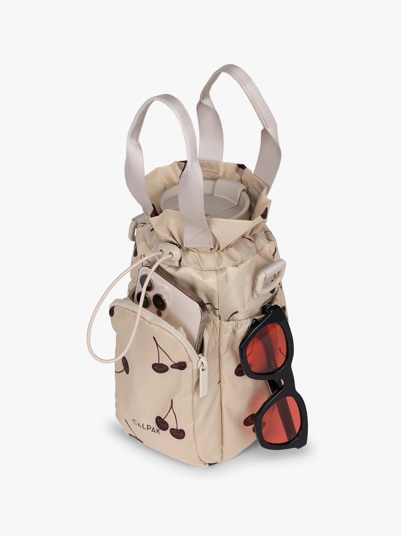 Water bottle in CALPAK Water Bottle Holder in Oatmeal Chery in beige with cherry pattern