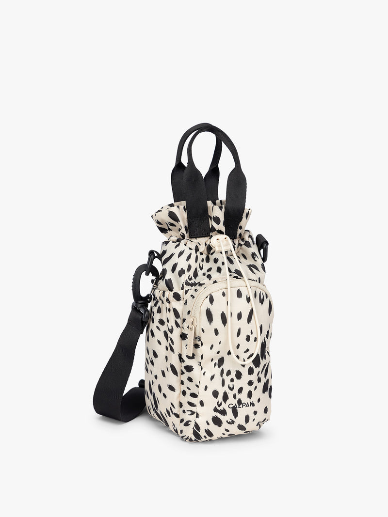 White and black animal print Snow Leopard CALPAK Water Bottle Holder with top handles, drawstring top, front zippered pocket, and a detachable shoulder strap