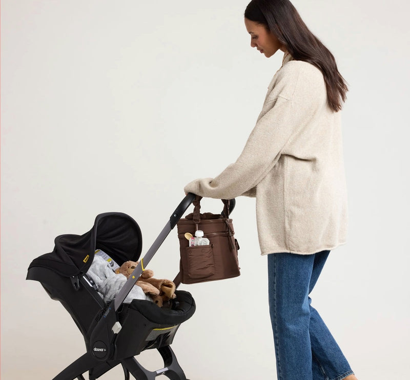 woman with stroller and CALPAK insulated baby bottle bag