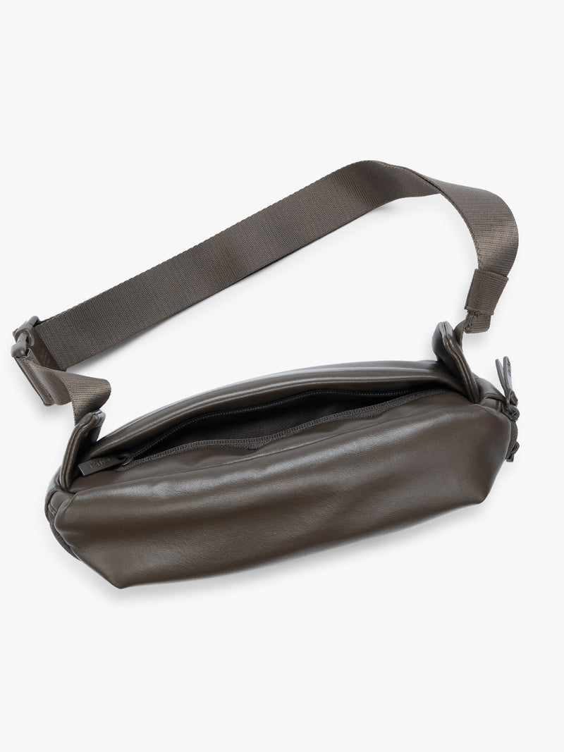 Top view showing backside zipper pocket of a dark brown Mushroom vegan leather CALPAK Luka Belt Bag with a zippered front pocket and side straps, shown against a plain white background