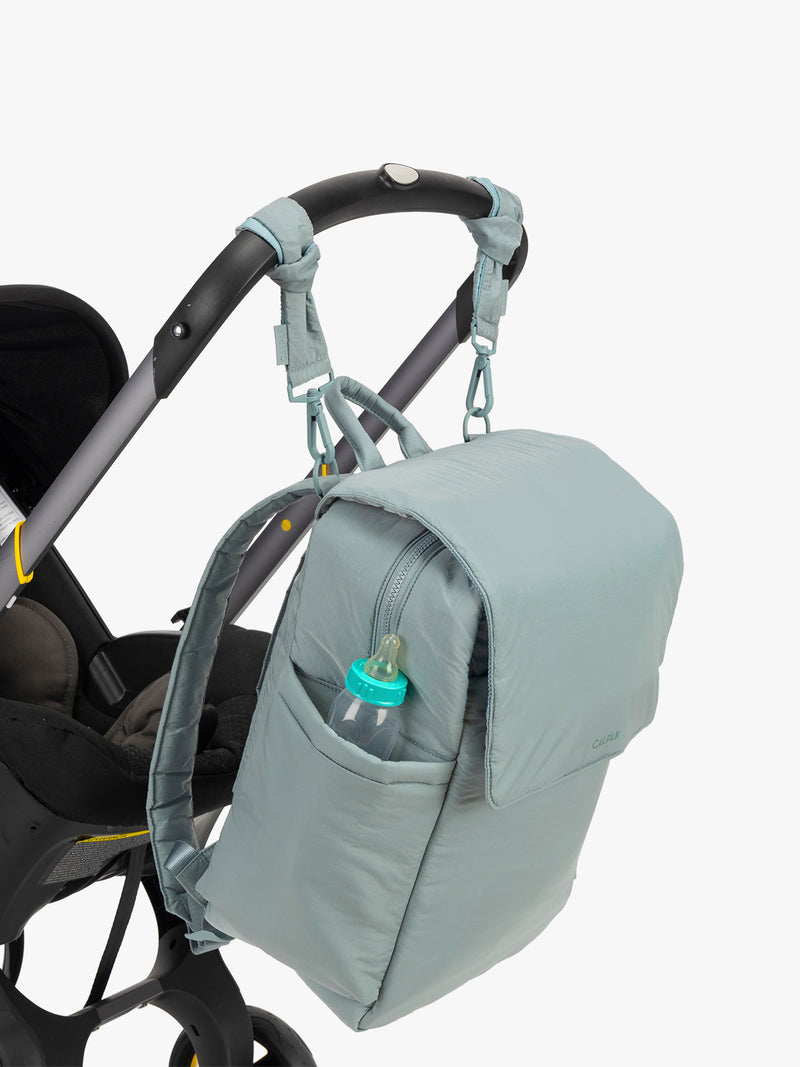 CALPAK Diaper Backpack in light blue Bluebell hanging on stroller with stroller straps