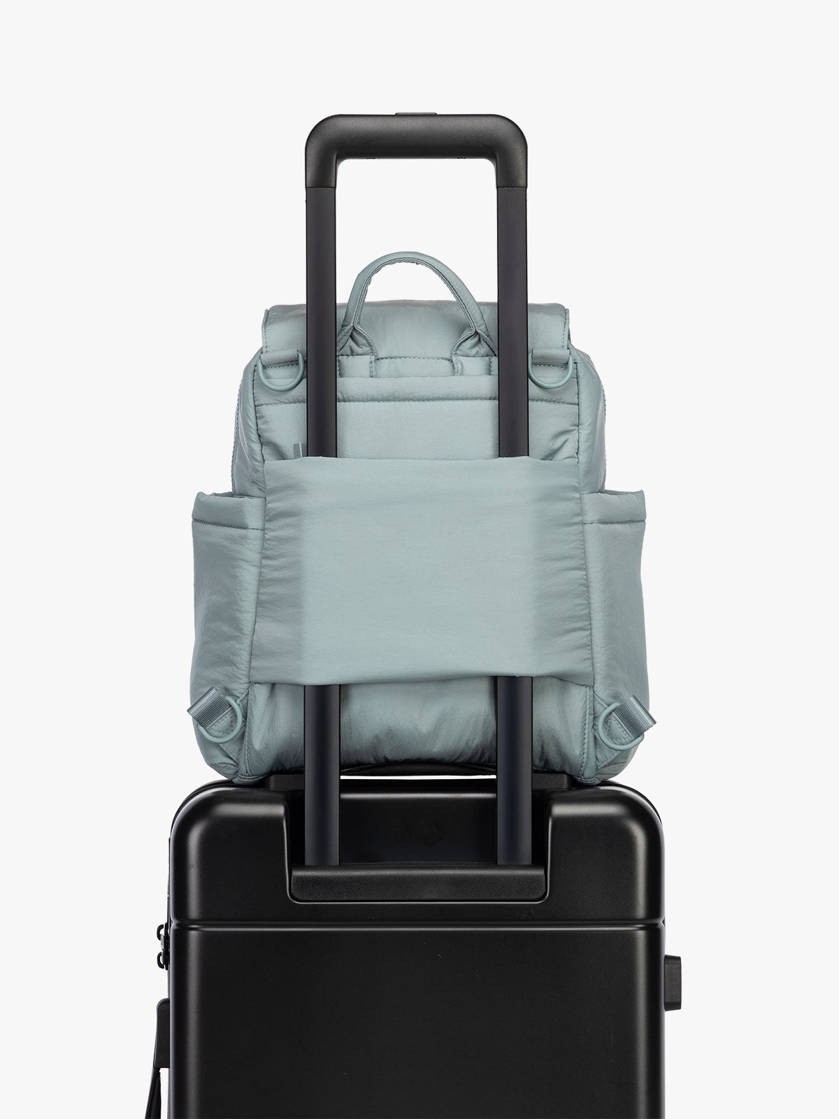 CALPAK Convertible Mini Diaper Backpack in light blue Bluebell on luggage with trolley sleeve; BPC2401-BLUEBELL