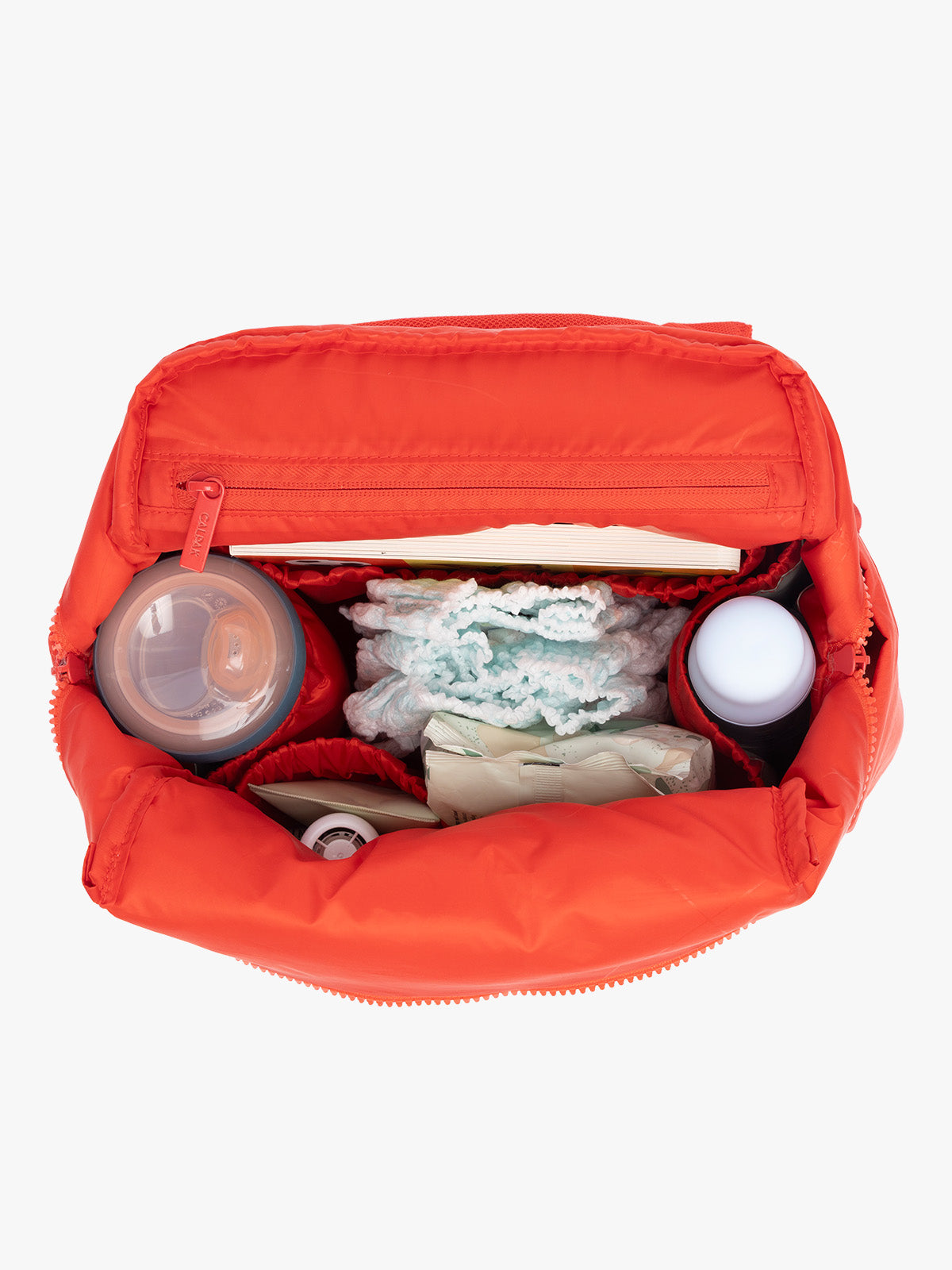 Baby items inside CALPAK Mini Diaper Backpack in red Tomato; BPC2402-TOMATO