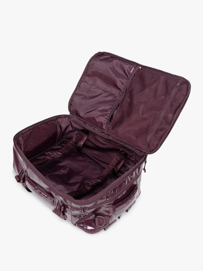 Opened CALPAK Terra 26L Laptop Backpack in dark red Dark Cherry with multiple pockets on a white background