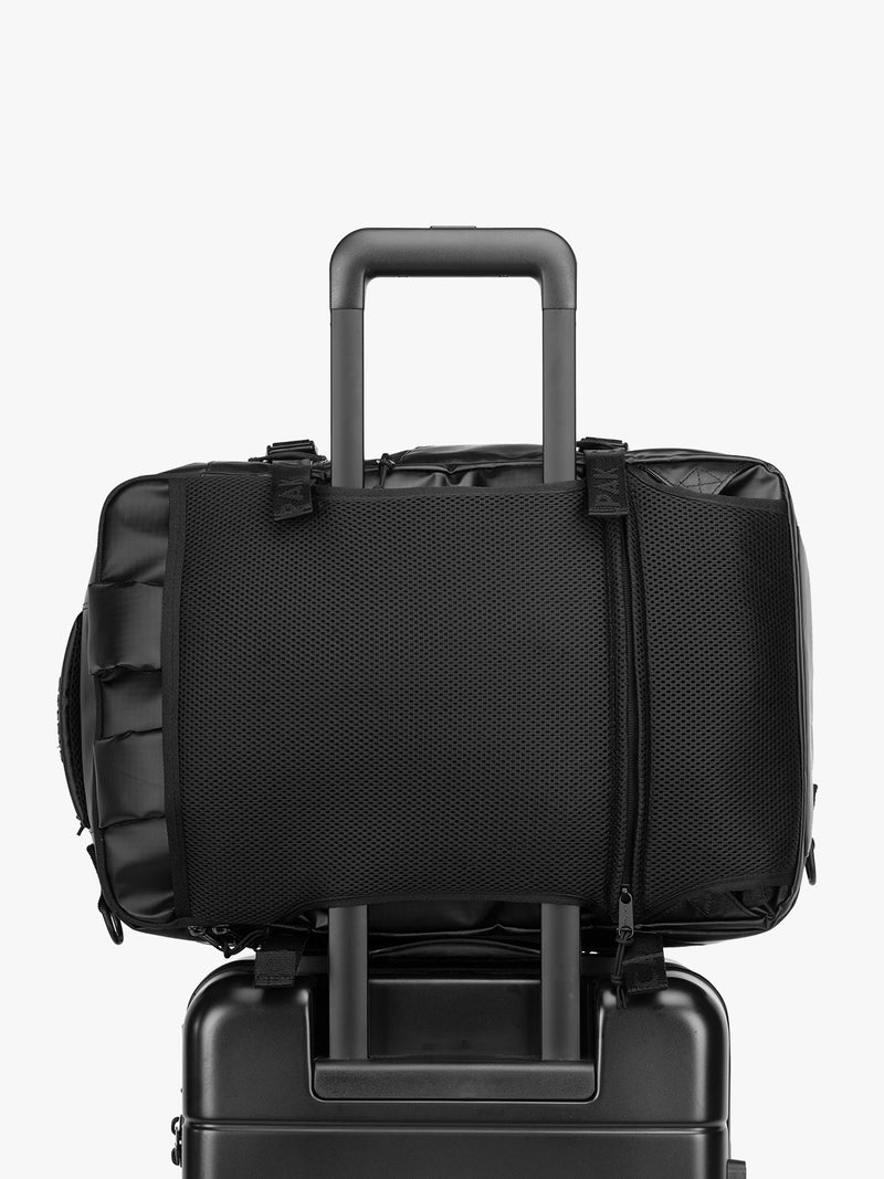 CALPAK Terra 26L Laptop Duffel Backpack in black Matte Obsidian on luggage with trolley sleeve