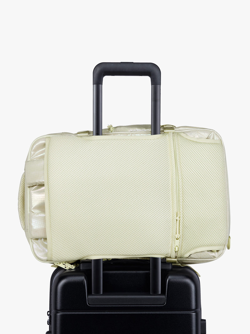 Luggage trolley sleeve of CALPAK Terra 26L Laptop Duffel Backpack with multiple pockets in shiny white Moonbeam on a white background