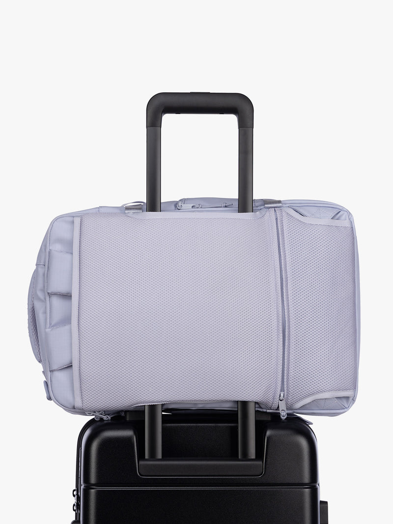 Luggage trolley sleeve of CALPAK Terra 26L Laptop Duffel Backpack with multiple pockets in light purple Sea Glass on a white background
