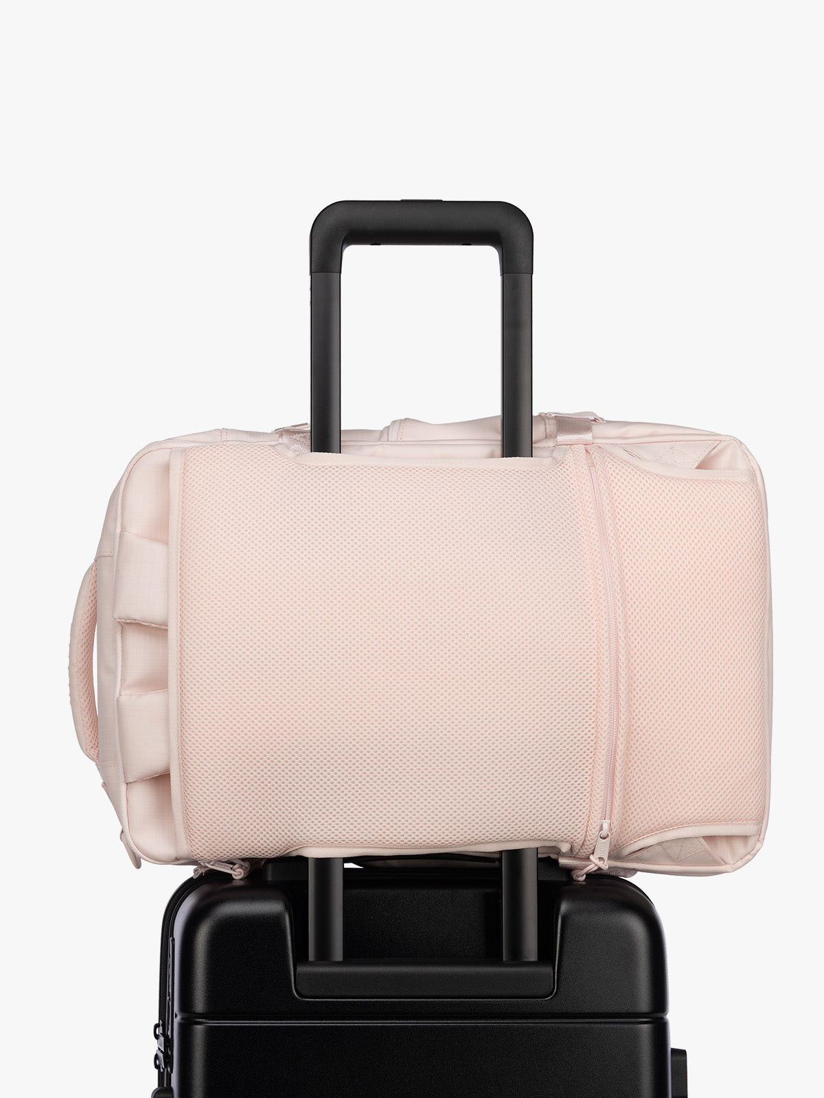 Luggage trolley sleeve of CALPAK Terra 26L Laptop Duffel Backpack with multiple pockets in light pink Shell Pink on a white background; BPH2201-SHELL-PINK