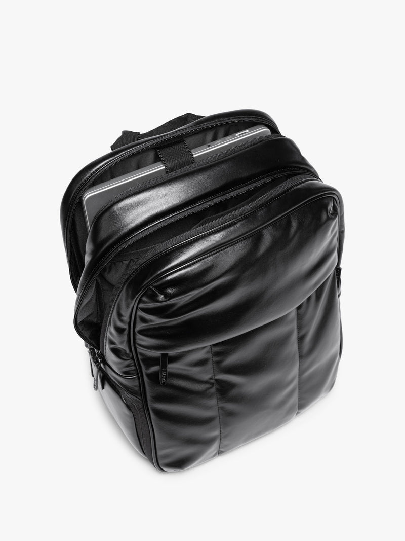 Laptop sleeve of Black CALPAK Luka 15 inch Laptop Backpack in vegan leather with a glossy finish, featuring a top carry handle, a main zippered compartment, and a front slip pocket, shown against a plain white background