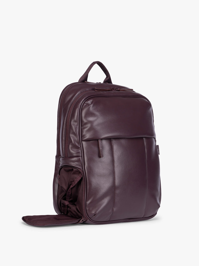 Side compartment of CALPAK Dark Cherry Luka 15 inch Laptop Backpack in vegan leather with a glossy finish, featuring a top carry handle, a main zippered compartment, and a front slip pocket, shown against a plain white background