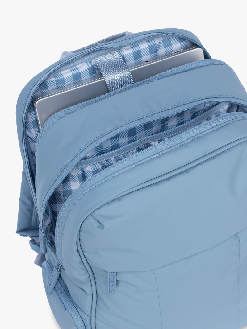 Opened view of the CALPAK Luka 15" Backpack in light blue French Blue with an interior white and blue gingham print