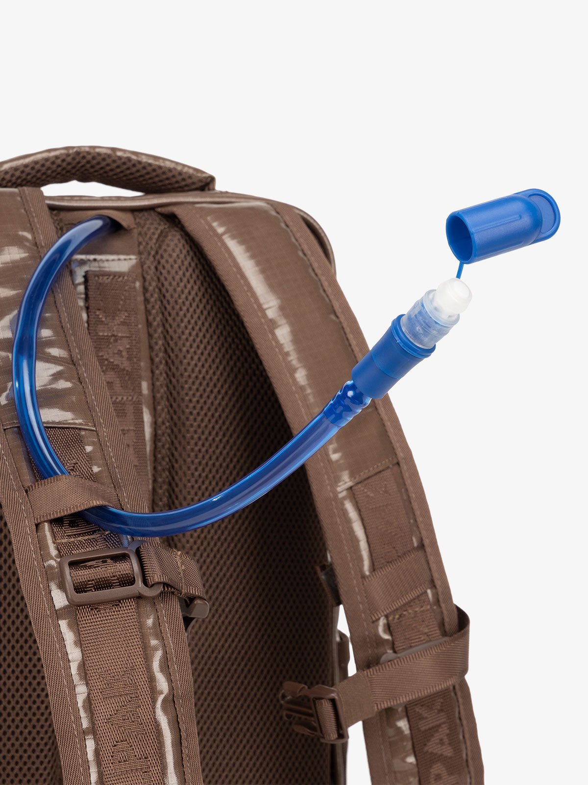 Close up of removable hydration reservoir straw with valve cap in brown