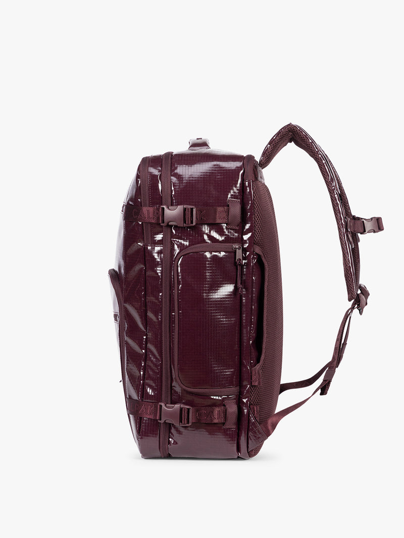 Side view of CALPAK Terra 35L Laptop Backpack Duffel in dark red Dark Cherry with tan accents on a white background