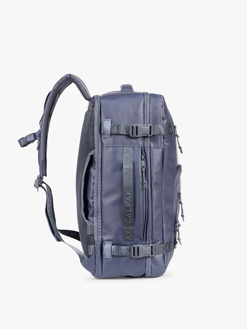 Side view CALPAK Terra 35L Laptop Backpack Duffel in matte dark blue Indigo with tan accents on a white background