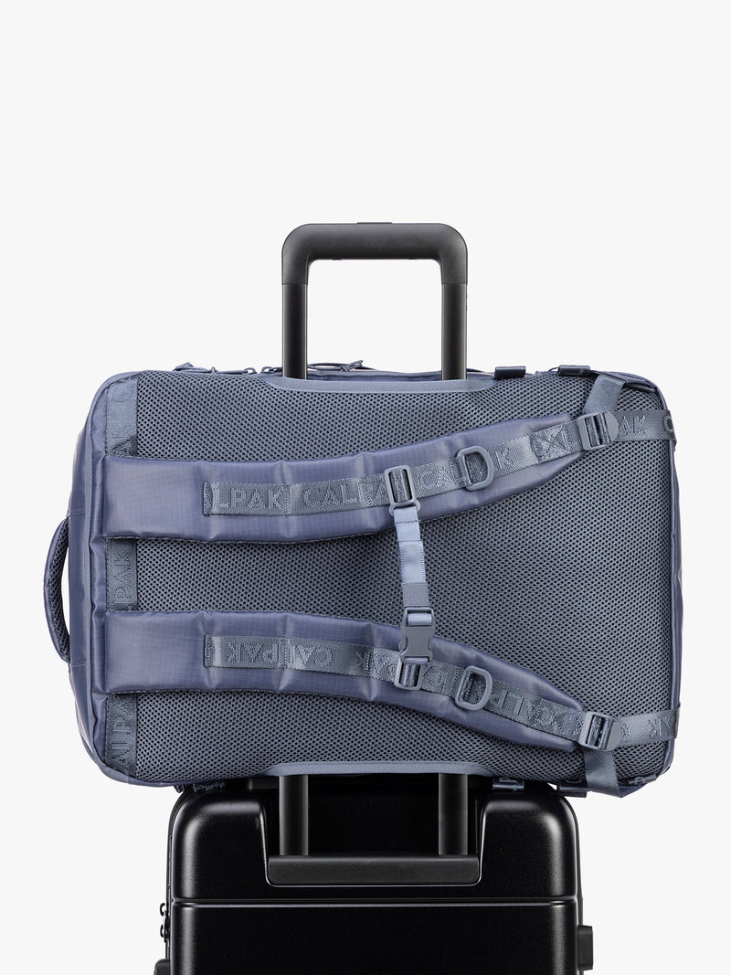 Back trolley sleeve of CALPAK Terra 35L Laptop Backpack Duffel in matte dark blue Indigo with tan accents on a white background