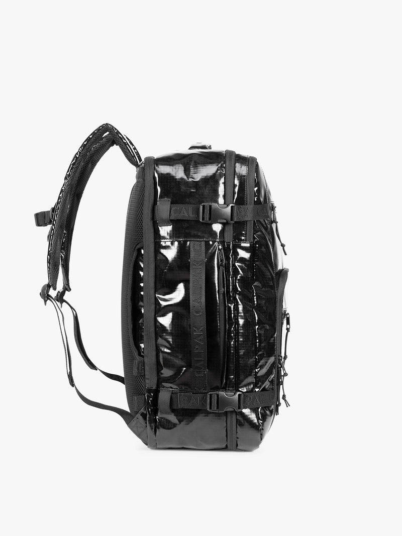 Side view of  the CALPAK Terra 35L Laptop Duffel Backpack in shiny black Obsidian on a white background