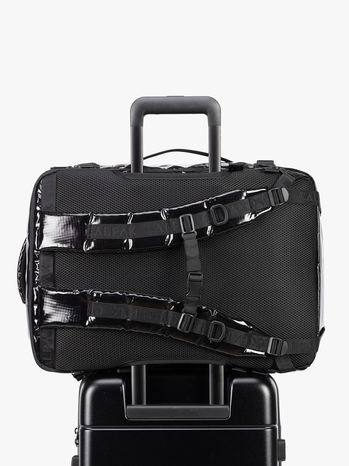 Back trolley sleeve of CALPAK Terra 35L Laptop Duffel Backpack in shiny black Obsidian on a white background; BPTL2601-OBSIDIAN