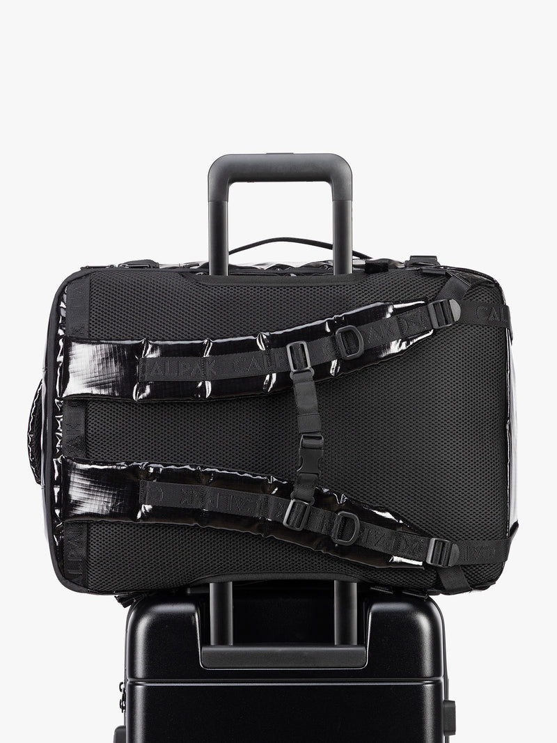 Back trolley sleeve of CALPAK Terra 35L Laptop Duffel Backpack in shiny black Obsidian on a white background