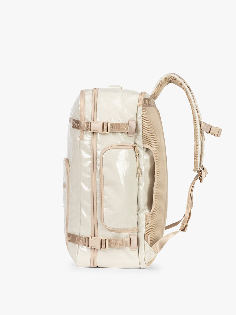 Side view of CALPAK Terra 35L Laptop Backpack Duffel in off-white White Sands with tan accents on a white background