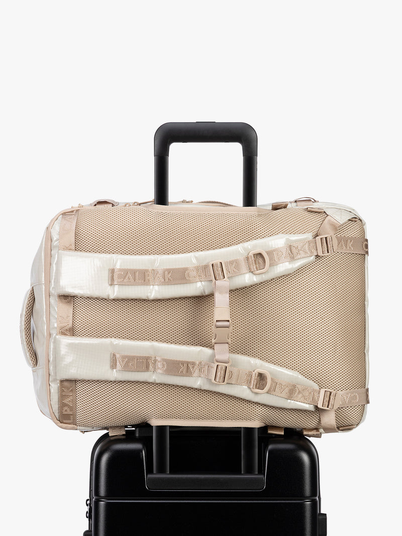 Back trolley sleeve of CALPAK Terra 35L Laptop Backpack Duffel in off-white White Sands with tan accents on a white background