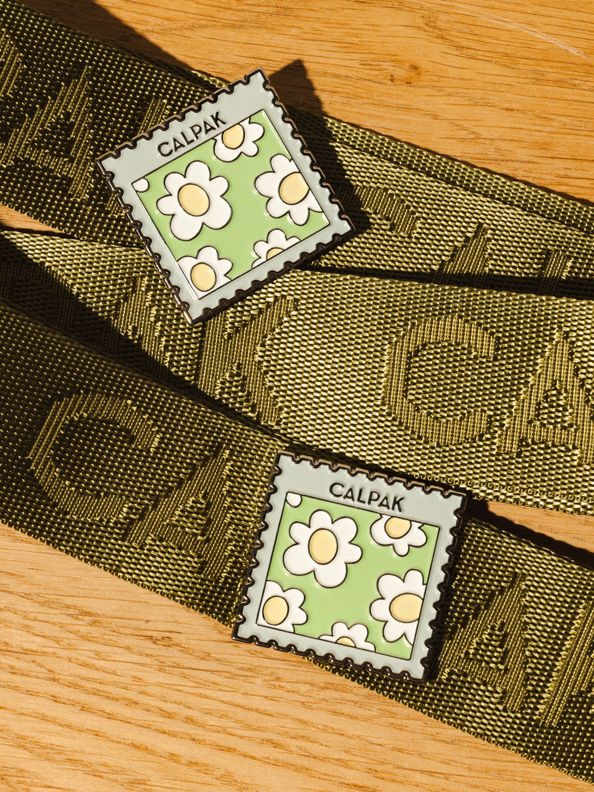 CALPAK Stamp Enamel pin with daisy print and CALPAK logo; CPP2401-STAMP