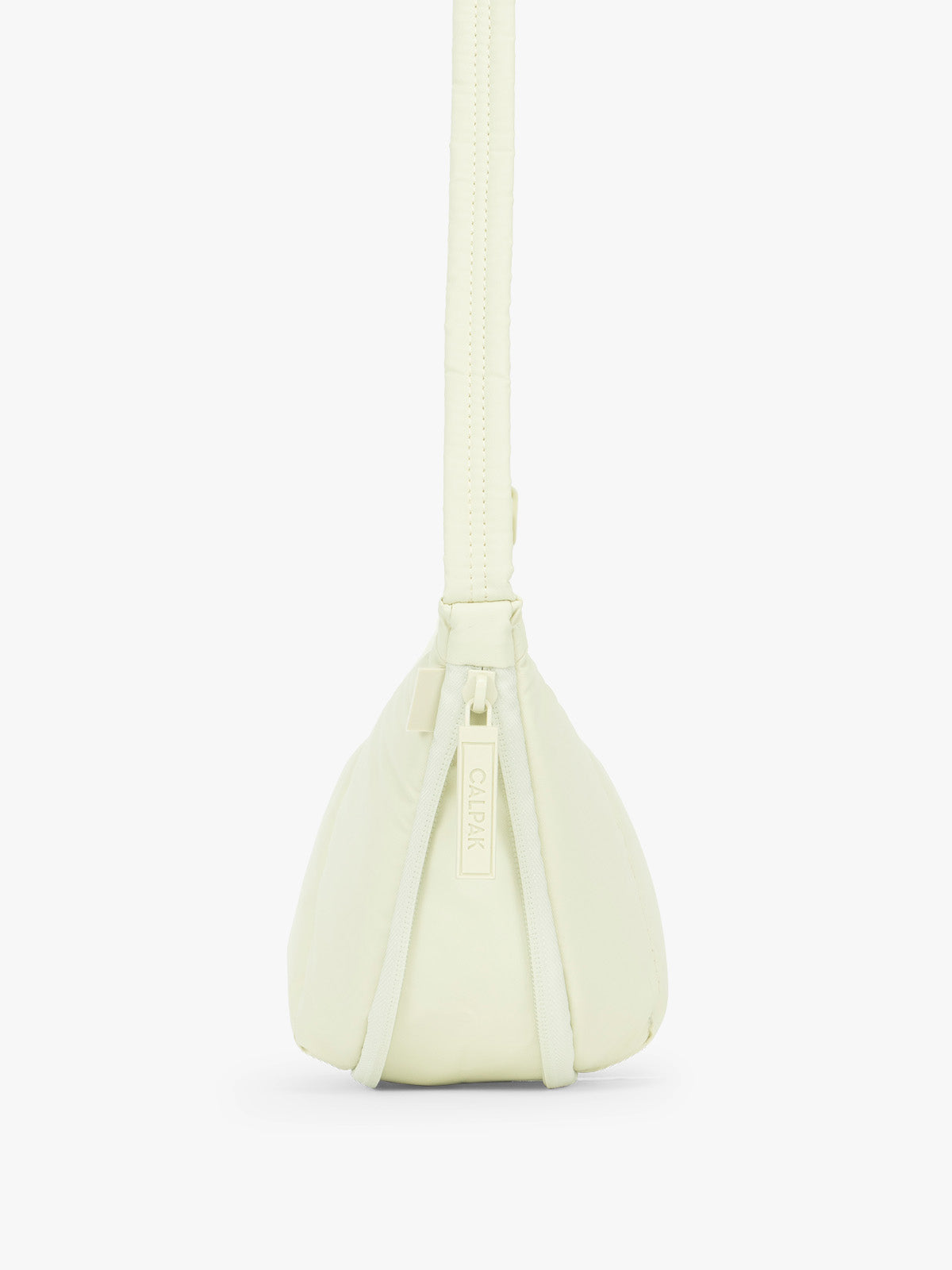 Side view showing expandable function of the CALPAK Luka Crescent Tote bag in light green Celadon with shoulder strap and bag is expandable up to 2" on a white background; CBL2601-CELADON