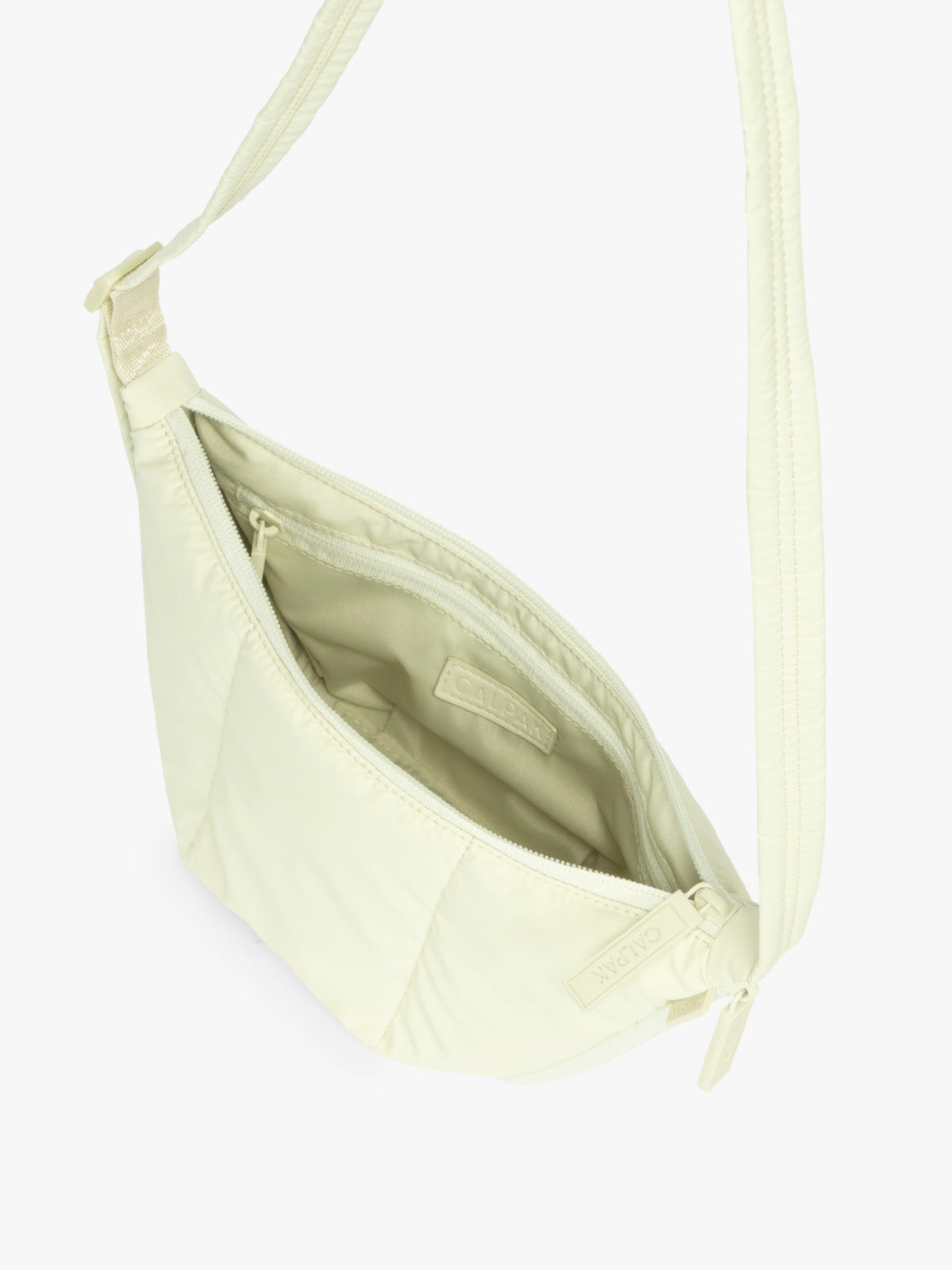 Opened interior of CALPAK Luka Crescent Tote bag in light green Celadon with shoulder strap and bag is expandable up to 2" on a white background; CBL2601-CELADON