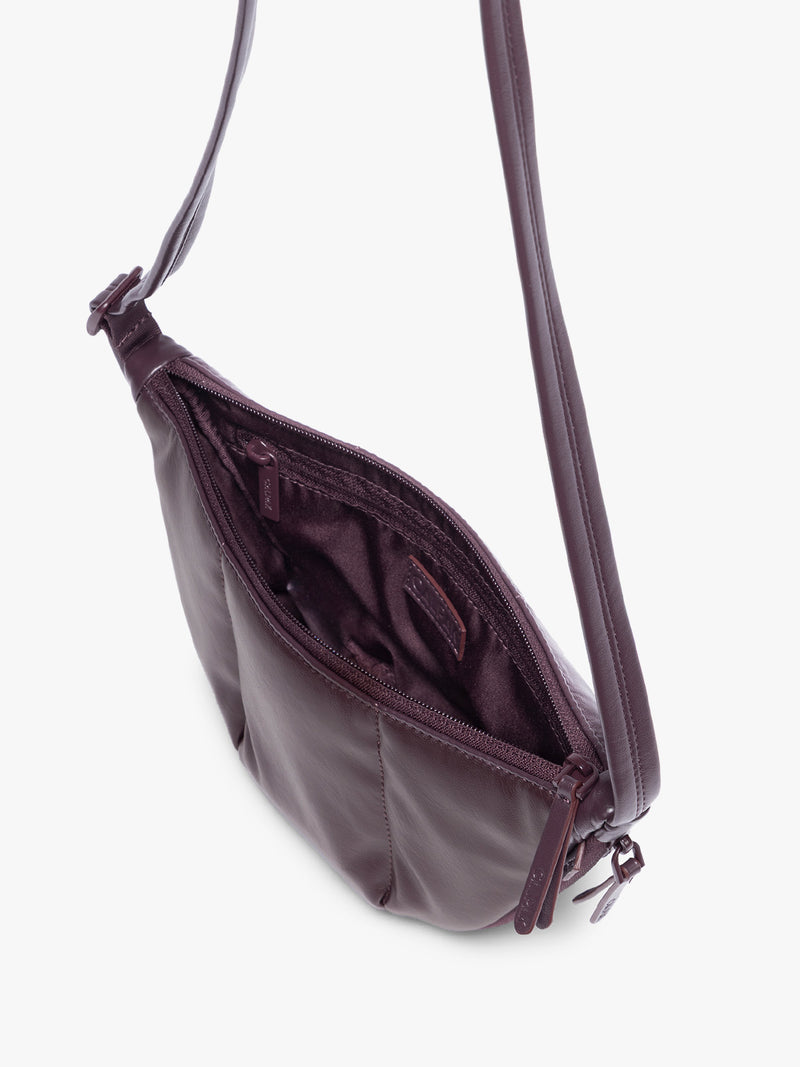 Top view of opened Dark Cherry deep burgundy vegan leather Luka Crescent shoulder bag with a long thin strap, shown against a plain light gray background