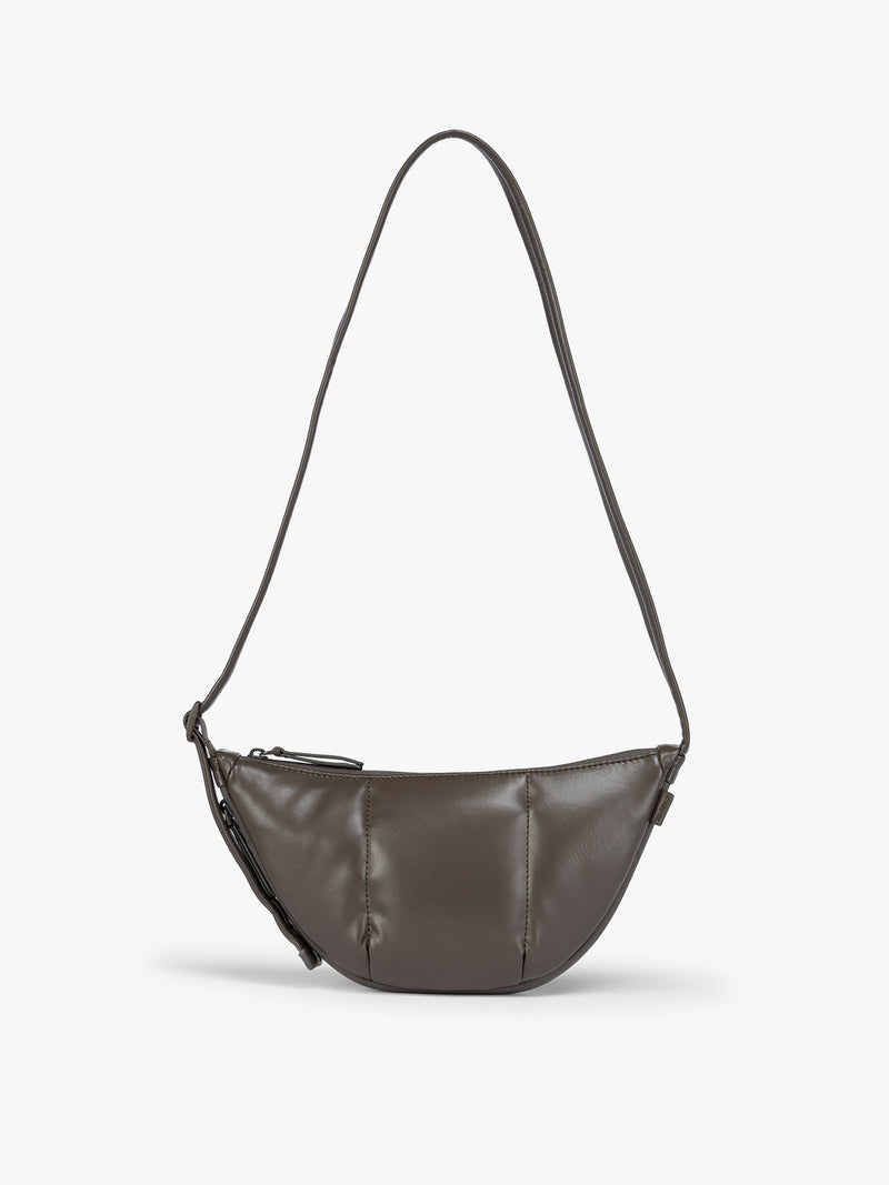 A dark brown vegan leather Luka Crescent shoulder bag with a long thin strap, shown against a plain light gray background