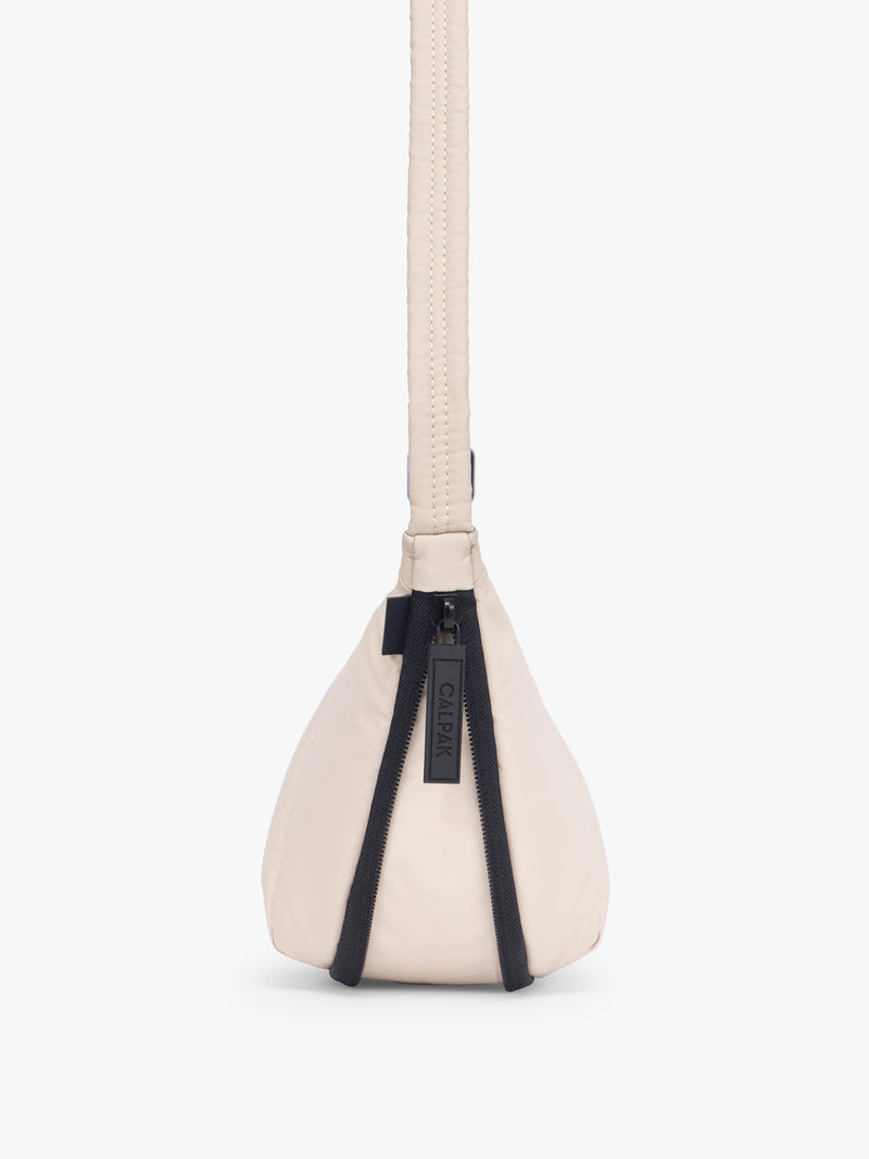 Side expandable zipper of CALPAK Luka Crescent Bag in beige off white Oatmeal